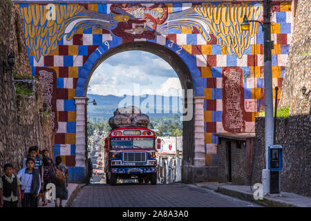 Un bus de poulet 'peint', comme les bus locaux sont appelés, entre dans l'entrée nord à Chichicastenango, Guatemala. Banque D'Images