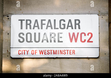 Londres - septembre 2019 : La lumière se reflète sur le mur de pierre tenant une plaque de rue pour Trafalgar Square, le monument public plaza à Westminster. Banque D'Images