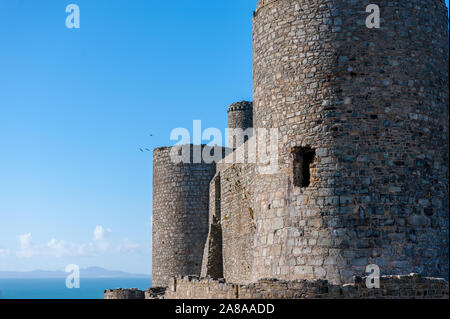 Les murs du château de Harlech au nord du Pays de Galles avec la péninsule Llyn au loin. Banque D'Images