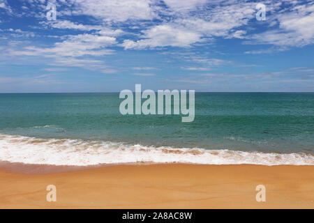 La plage de sable tropicale, vue panoramique de la côte de la mer jaune vide avec du sable et de l'onde émeraude avec mousse blanche. Seascape pittoresque avec ciel bleu Banque D'Images