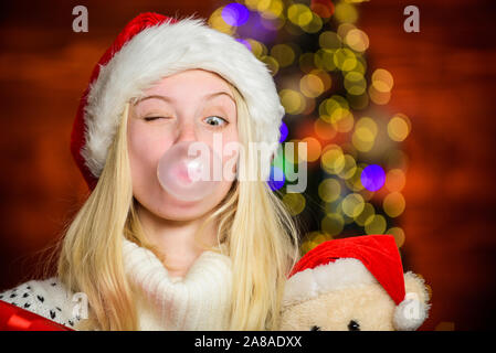 Respirez doucement. Faire des bulles avec de la gomme. Seulement amusant sur mon esprit. Fille du Père Noël, faisant de grands avec de la gomme à bulles. Funny face close up. Adorable woman blowing bubble. Fille de noël faites bubble-gum. Banque D'Images