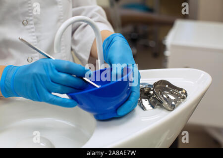 Dentiste de détail mains tenant les outils dentaires dans une clinique dentaire. Banque D'Images