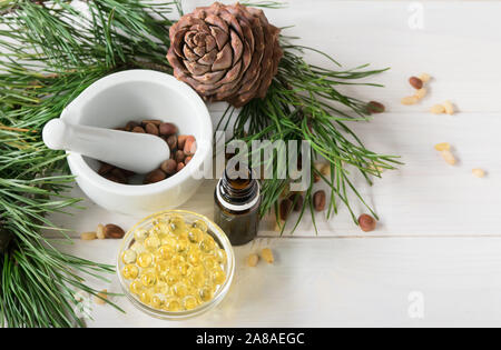 Les écosystèmes naturels, la composition du produit des bouteilles en verre avec de l'huile de cèdre, noix de pin, mortier, huile essentielle de cèdre. Banque D'Images