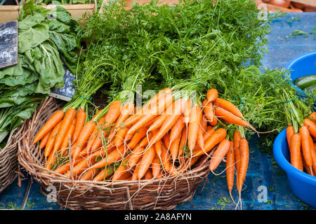 Carottes fraîches pour la vente dans un panier en osier sur un étal du marché Banque D'Images