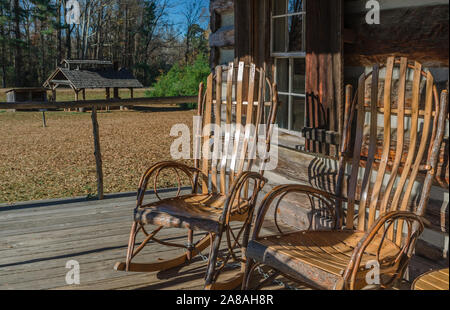 Faites-Amish rockers s'asseoir sur le perron de la Cabane en bois Cadeaux en français Camp, Mississippi. Banque D'Images