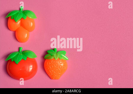 Les fruits et légumes en plastique collection isolé sur fond rose Banque D'Images