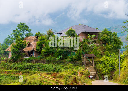 Maisons et maisons sur haut des rizières en terrasses à l'extérieur du magnifique village de Sapa au nord du Vietnam, entourée de montagnes Banque D'Images