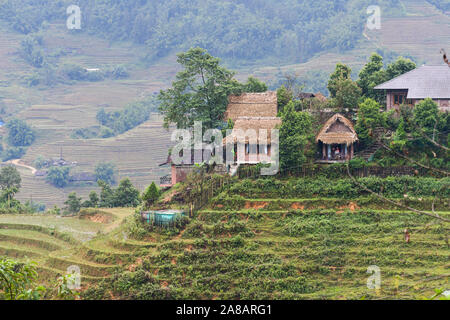 Maisons et maisons sur haut des rizières en terrasses à l'extérieur du magnifique village de Sapa au nord du Vietnam, entourée de montagnes Banque D'Images