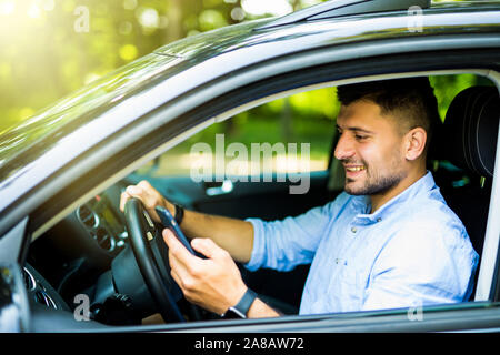 La conduite de l'homme dans sa voiture à l'aide de téléphone mobile cellulaire, situation dangereuse Banque D'Images