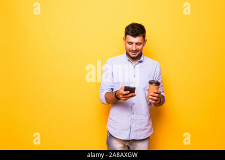 Photo de belle man et café à emporter sur fond jaune isolé Banque D'Images