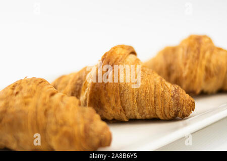 Trois croissants sur une plaque portait sur le centre une sur fond blanc Banque D'Images