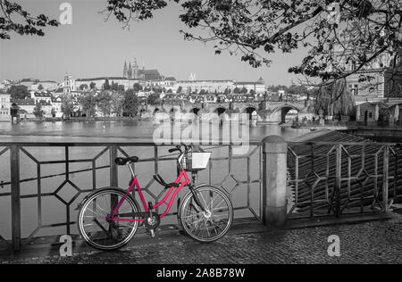 Prague - Le vélo de location au bord de l'eau,le Pont Charles, le château et la cathédrale en arrière-plan. Banque D'Images