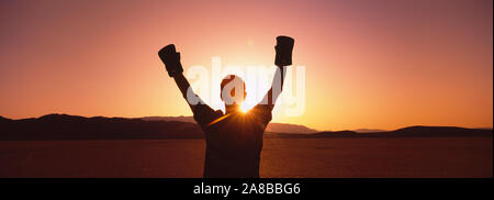 Silhouette d'une personne portant des gants de boxe dans un désert au crépuscule, Black Rock Desert, Nevada, USA Banque D'Images