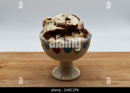 Tasse de crème glacée Tiramisu sur table en bois, fond blanc. Banque D'Images