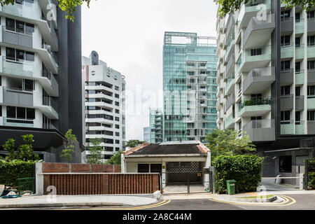 Un petit délabré vieille propriété privée house sitting in-entre de hauts l'immeuble d'immeubles modernes. Banque D'Images