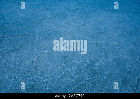 Résumé fond vide naturellement créés par de petites vagues en eaux peu profondes et de la lumière du soleil les réflexions sur la surface de l'eau. Tonique dans les tons de lumière b Banque D'Images