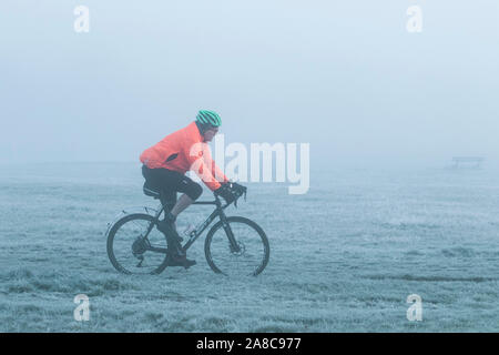 Londres, Royaume-Uni. Nov 8, 2019. Un homme cylces grâce à un paysage couvert de brouillard sur Wimbledon Common, par un froid matin de novembre . Credit : amer ghazzal/Alamy Live News Banque D'Images