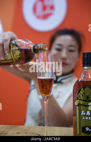 Shanghai, Chine, la Province de Zhejiang. Nov 8, 2019. Un membre du personnel sert du vin durant le Salon International de l'industrie du vin de riz chinois à Shaoxing, Province de Zhejiang en Chine de l'Est, le 8 novembre, 2019. Credit : Xu Yu/Xinhua/Alamy Live News Banque D'Images