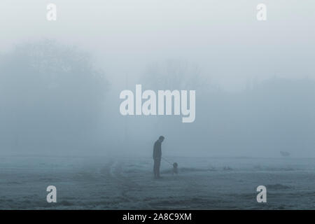 Londres, Royaume-Uni. Nov 8, 2019. Un homme marche à travers un paysage couvert de brouillard sur Wimbledon Common, par un froid matin de novembre . Credit : amer ghazzal/Alamy Live News Banque D'Images