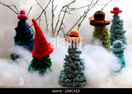 Groupe d'usure de l'arbre de Noël vert chapeau coloré crocheté à partir de fils pour faire l'ornement fait main pour les vacances d'hiver, à l'hiver sur fond blanc, mignon Banque D'Images