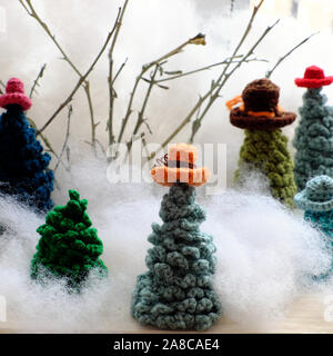 Groupe d'usure de l'arbre de Noël vert chapeau coloré crocheté à partir de fils pour faire l'ornement fait main pour les vacances d'hiver, à l'hiver sur fond blanc, mignon Banque D'Images