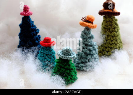 Groupe d'usure de l'arbre de Noël vert chapeau coloré crocheté à partir de fils pour faire l'ornement fait main pour les vacances d'hiver, à l'hiver sur fond blanc, mignon Banque D'Images