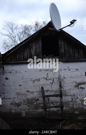 Antenne Satellite sur un vieux village grange. Banque D'Images