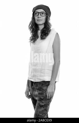 Studio shot of young Beautiful woman standing et de penser tout en portant des lunettes Banque D'Images