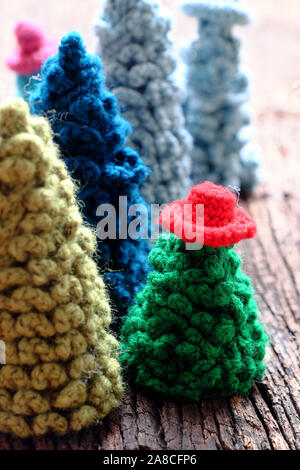 Groupe d'ornement fait main pour la saison d'hiver en hiver, l'arbre de Noël au crochet de l'usure du fil vert chapeau coloré sur fond sombre, amazing craft Banque D'Images