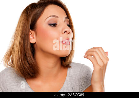 Jeune femme avec son séchage du vernis à ongle blowing Banque D'Images