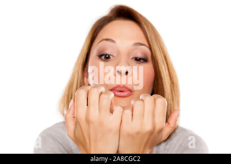 Jeune femme avec son séchage du vernis à ongle blowing Banque D'Images