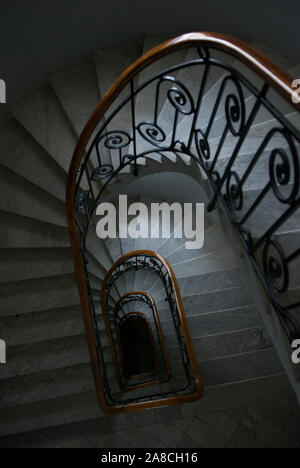 Escalier colonial français vintage en marbre blanc avec bois poli et balustrade en fer forgé Banque D'Images