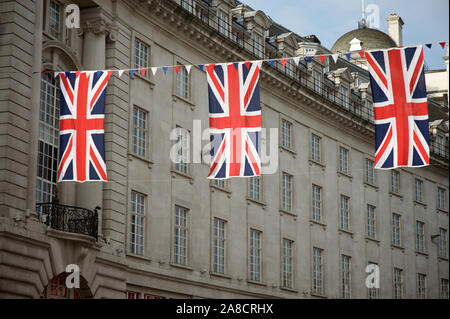 Union Jack flag décorations suspendus au-dessus des rues de Londres, Royaume-Uni, sous le ciel bleu doux Banque D'Images