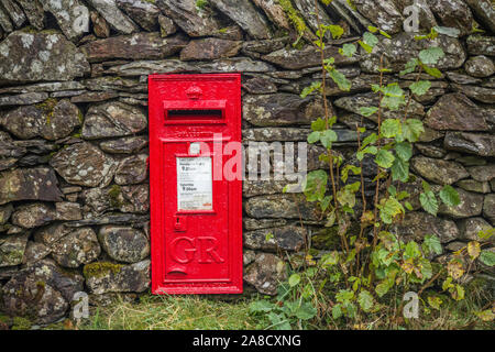 GR rouge dans une boîte aux lettres près de mur de pierres sèches Loughrigg Tarn dans le Parc National de Lake District Cumbria Banque D'Images