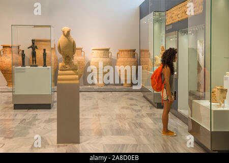 Héraklion, Crète, Grèce. Jeune femme admirant objets anciens sur l'affichage dans le musée archéologique d'Héraklion. Banque D'Images