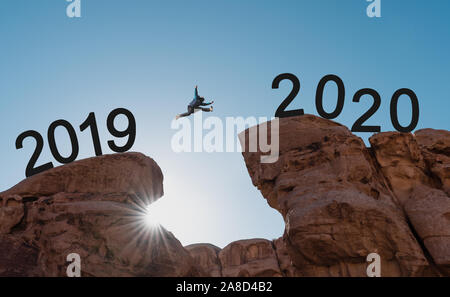 Silhouette d'un homme sautant sur falaise de 2019 à 2020 Banque D'Images
