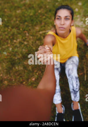 Deux jeunes femmes athlètes tiennent la main montrant le soutien et relation amicale lors de l'entraînement - ami tendre la main à un Banque D'Images