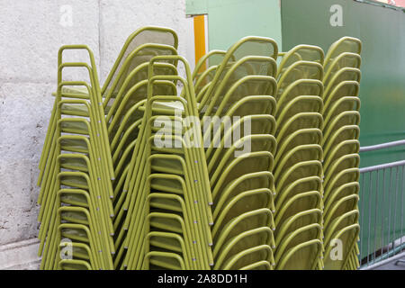 Des chaises en métal vert superposés à l'avant du restaurant Banque D'Images