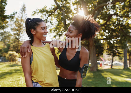 Portrait of a smiling woman hugging multiethnique dans un parc sur summers day - exercice heureux friends smiling together in a park Banque D'Images
