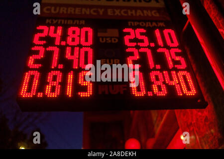 Les taux de change en rouge brillant Plaque de rue la nuit avec cyrillique mots pour acheter et vendre des USD et EUR calculé en monnaie nationale Banque D'Images
