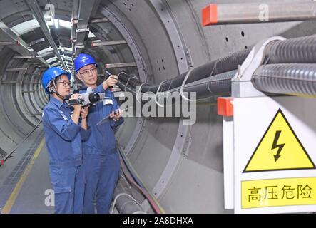 Les travailleurs chinois à partir de l'alimentation locale de patrouille et inspection bureau 220kv câbles d'alimentation haute tension souterrain monté à Foshan, Chine du sud' Banque D'Images