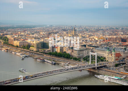 Une vue panoramique depuis la colline Gellert sur la ville de Budapest, magnifiquement illuminée par le soleil, le Danube avec le pont Elisabeth et les bateaux de croisière. Banque D'Images