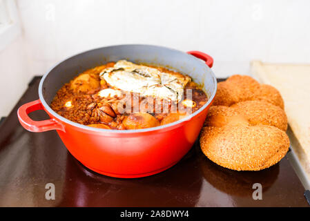 La plaque chaude pour le Sabbat, un pot de viande épicé cuit avec pommes de terre, blé, orge et d'œufs. Pot de tcholent Hamin en hébreu, challah-pain spécial dans une cuisine juive. La nourriture traditionnelle Shabbat juif. Banque D'Images