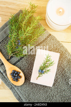 Mise à plat voir l'Amérique Juniper Juniperus communis berry bar soap, juniper tree branch avec cônes confier et cuillère avec des baies, copiez l'espace. Tre Juniper Banque D'Images