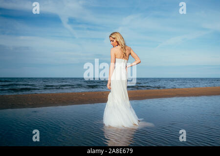 Portrait of young blonde bride restant entre l'eau, les yeux fermés Banque D'Images