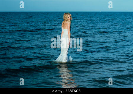 Portrait of young blonde bride restant entre l'eau, à la recherche de l'appareil photo Banque D'Images