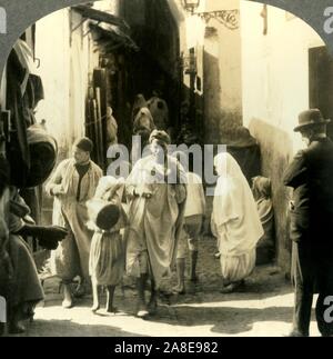 'Agent Hommes et femmes voilées foule cette rue étroite dans le quartier arabe d'Alger Algérie', c1930s. À partir de la "Tour du monde". [Keystone View Company, Meadville, Pennsylvanie, New York, Chicago, Londres] Banque D'Images