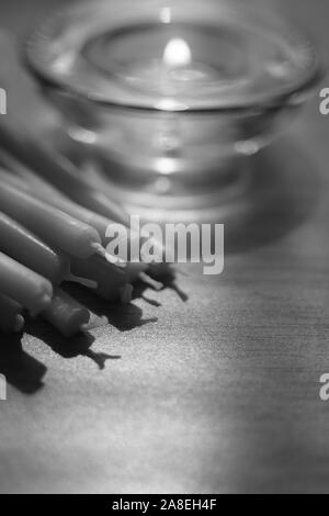 Des tas de nouvelles bougies et d'une bougie brûle dans une basse ronde verre chandelier, macro, P.C. Banque D'Images