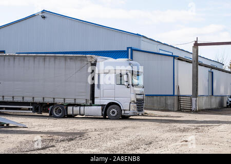 Camions modernes de diverses couleurs et modèles sont impliqués pour le transport de différents types de marchandises commerciales sont dans une rangée sur l'arrêt de camion dans Banque D'Images