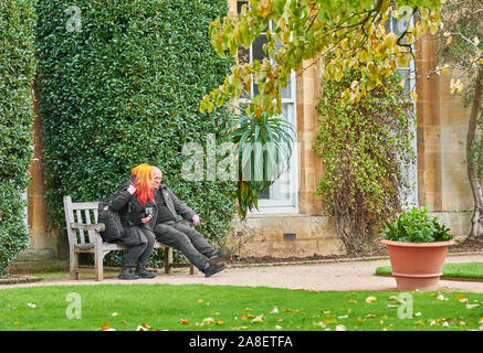 Un couple s'asseoir sur un banc à la fin de l'automne au jardin botanique de l'université d'Oxford, en Angleterre. Banque D'Images